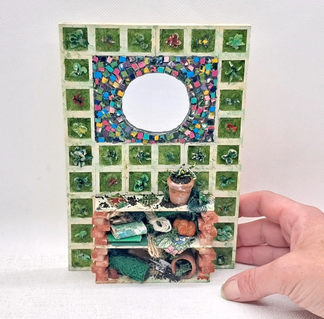 A dolls house garden item with mosaic mirror, a potting bench and 30 panels of vertical wall garden.