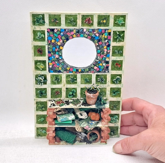 A dolls house garden item with mosaic mirror, a potting bench and 30 panels of vertical wall garden.