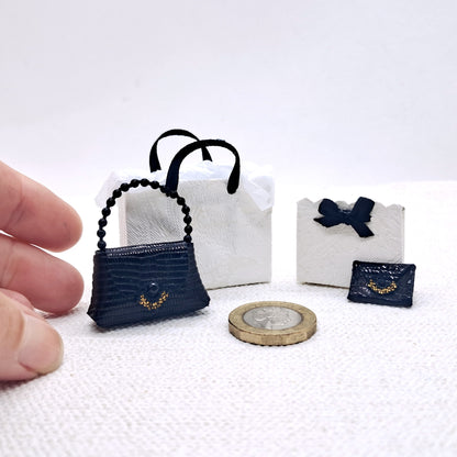 dolls house miniature luxury fashion set. A black leather handbag, matching purse and two luxury shopping bags